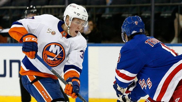 New York Islanders right wing Simon Holmstrom plays the puck...