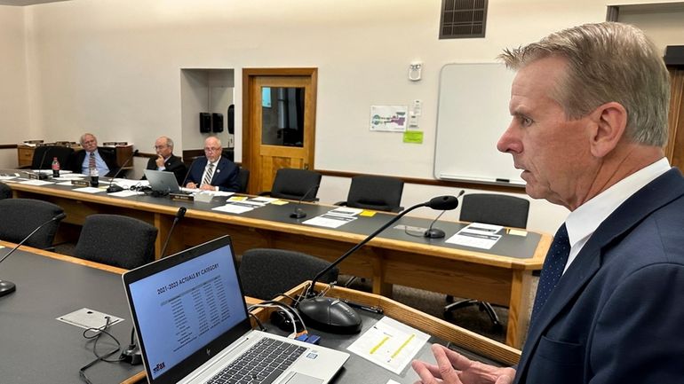 North Dakota state Tax Commissioner Brian Kroshus, right, offers input...