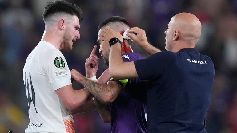 Fiorentina's Cristiano Biraghi is treated after being hit by an...
