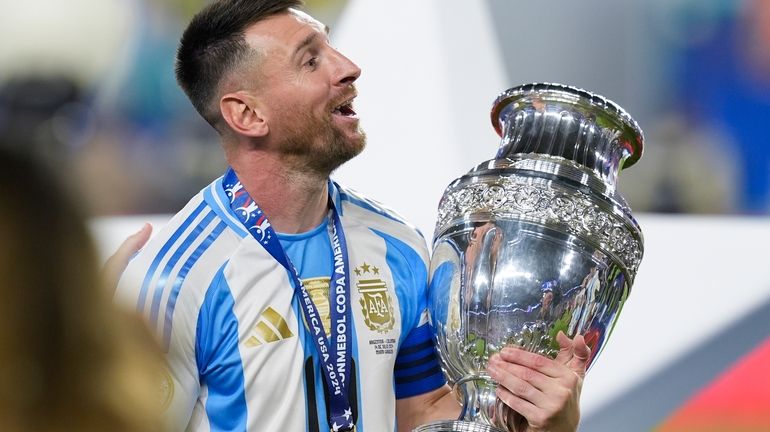 Argentina's Lionel Messi celebrates with the trophy after his team...