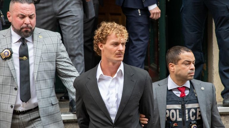 Daniel Penny, center, after surrendering to the NYPD on May 12...