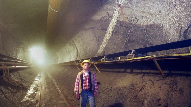 Inside a water tunnel 670 feet below Queens streets, a...