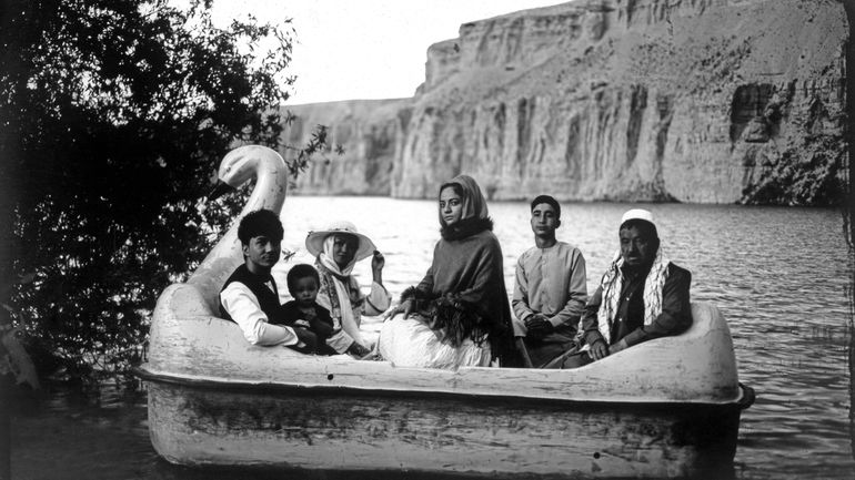 The Moradi family sits for a portrait on a small...