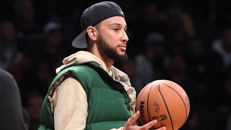 Nets guard Ben Simmons holds a ball during a timeout...