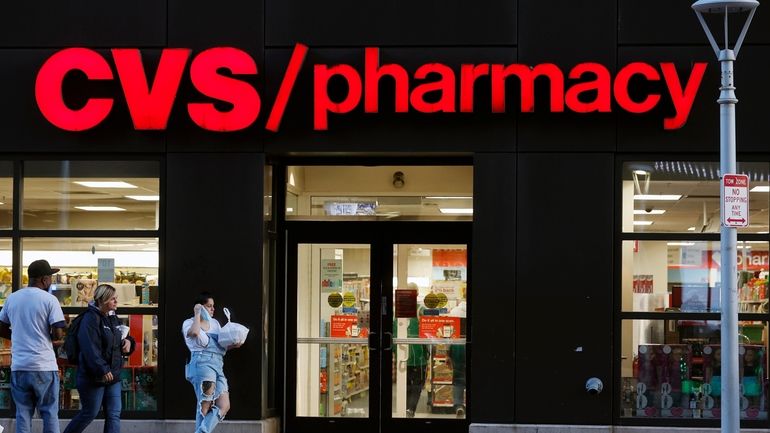 Customers walk to a CVS Pharmacy, Friday, Nov 4, 2022,...