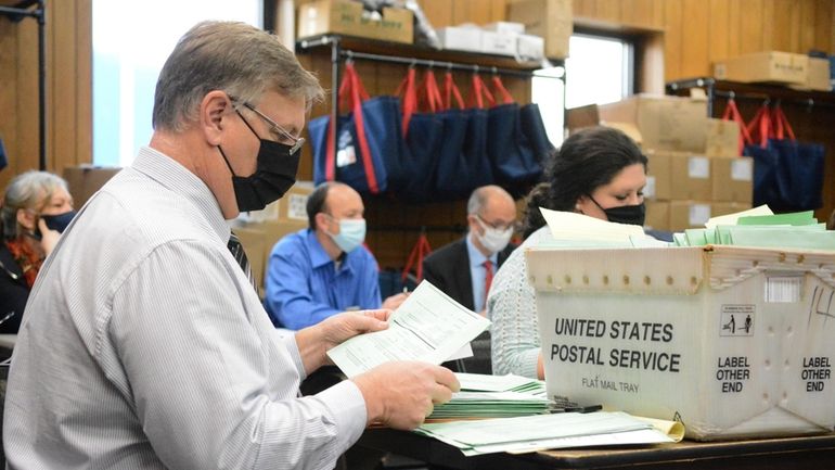 Election Bureau Director Albert L. Gricoski, left, opens provisional ballots...