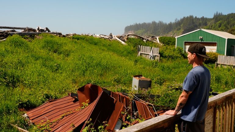 Sonny Curley looks out to the seawall separating his property...