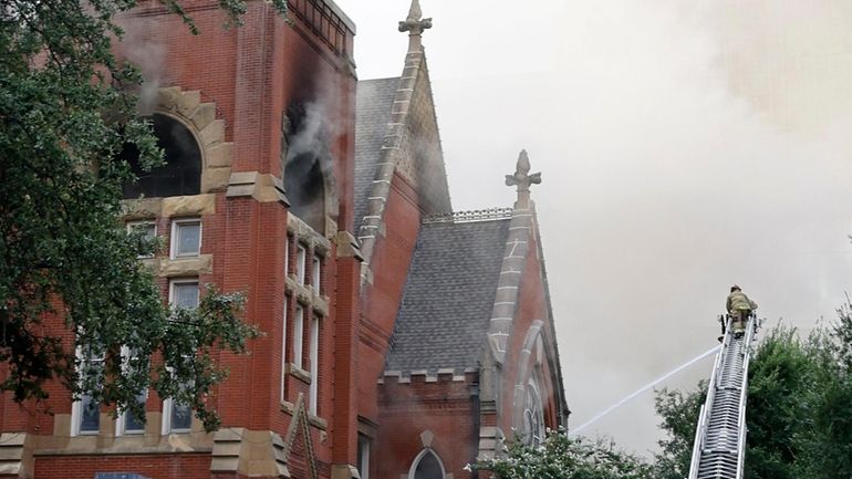 Firefighters work at the scene of a fire at First...