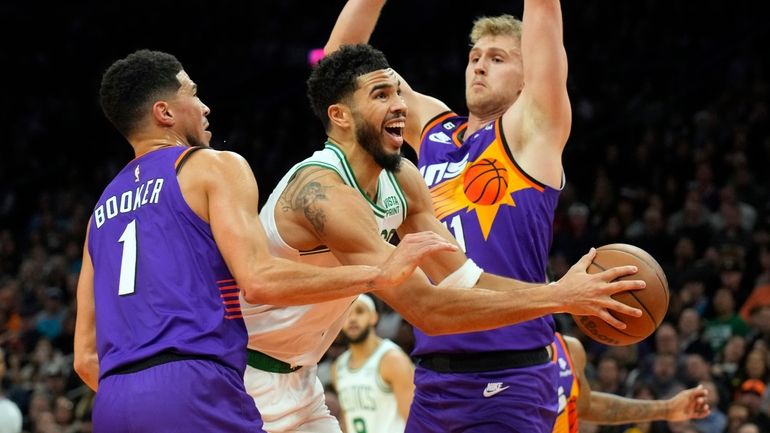 Boston Celtics forward Jayson Tatum (0) drives between Phoenix Suns...