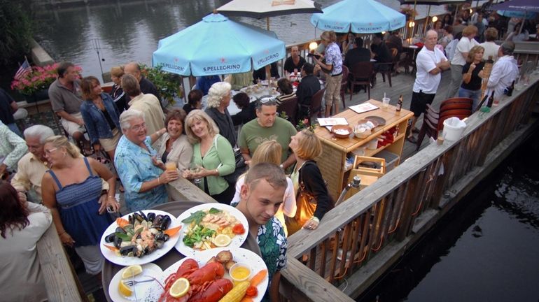 A waiter delivers an order of lobster, sea scallop scampi...