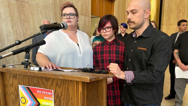 Parents Devon and Robert Dolney, of Fargo, stand with their...