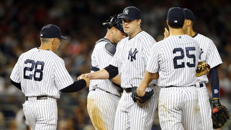 Shawn Kelley #27 of the Yankees hands the ball to...