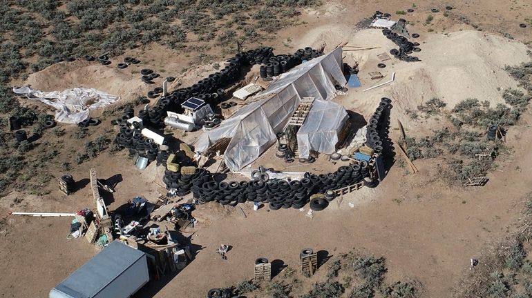 A ramshackle compound is seen in the desert area of...