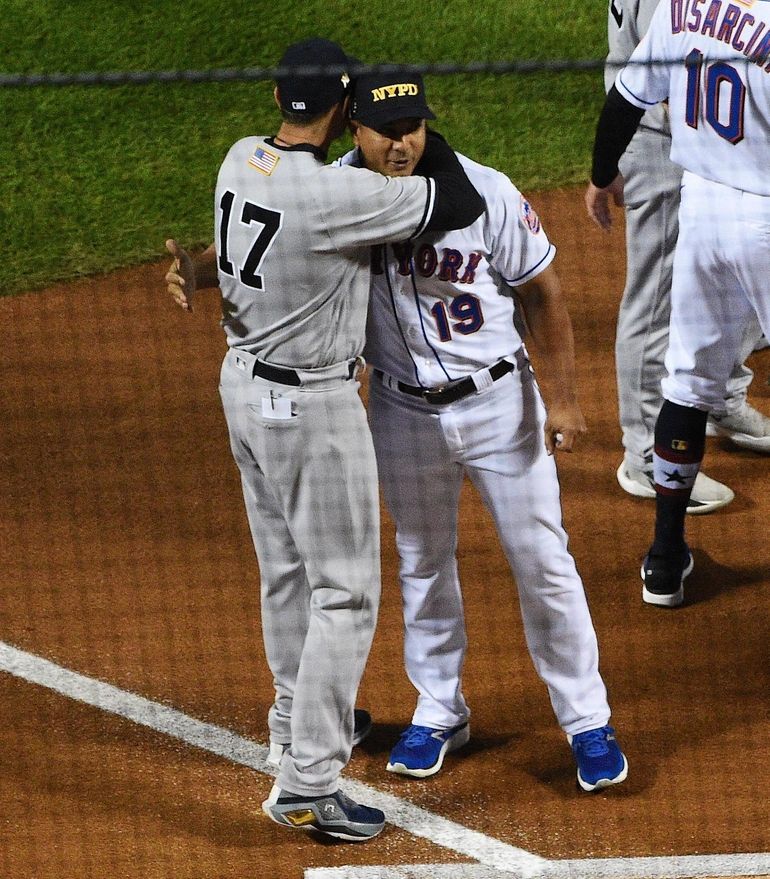 The New York Yankees and the New York Mets shake hands before lining up  together along the baselines for the 20th anniversary of the 9/11 terrorist  attacks before a baseball game on