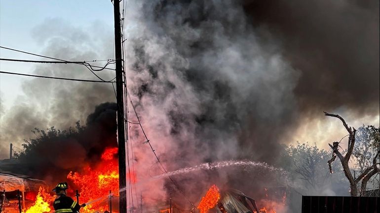 This image provided by Mark Matta shows a firefighter working...