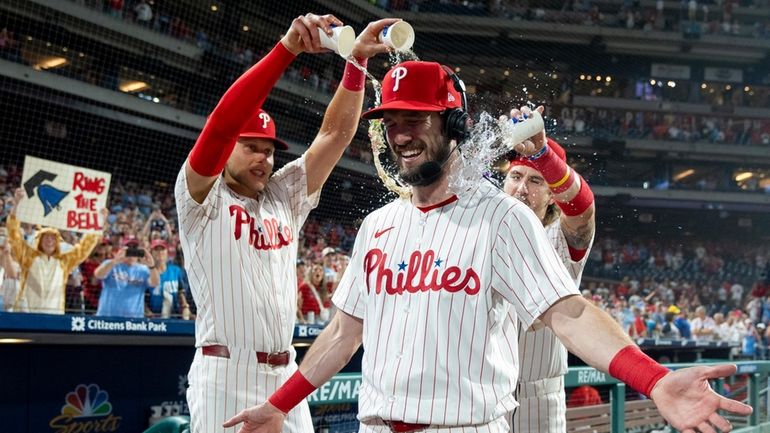 Philadelphia Phillies' David Dahl, center, is doused by Alec Bohm,...