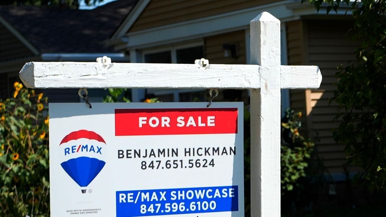 A "For Sale" sign is displayed in front of a...