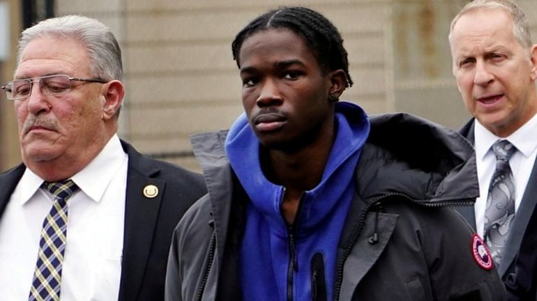 Darin Semple, center, leaves Nassau police headquarters in Mineola on Dec. 11,...