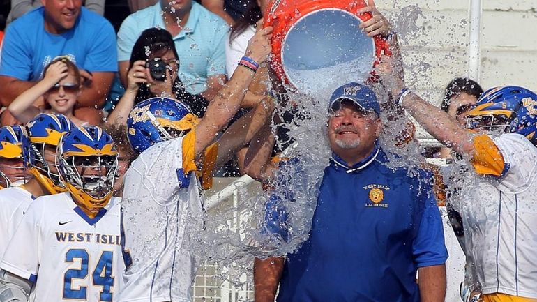 West Islip's head coach Scott Craig gets the water bath...