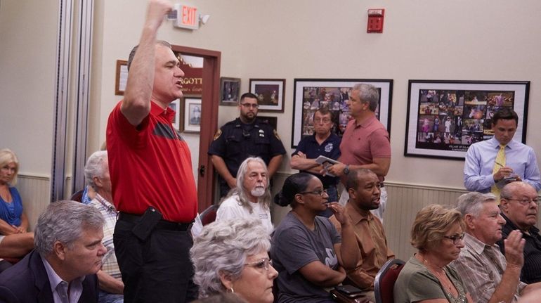 Martin Dettling protests as Village Mayor Allan M. Dorman reads...