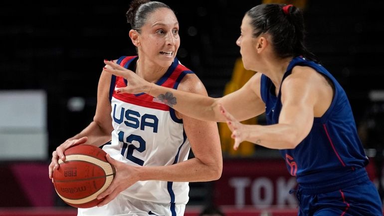 United States' Diana Taurasi (12) drives around Serbia's Sasa Cado...