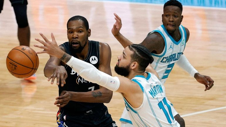 Kevin Durant of the Nets looks to pass against Cody...