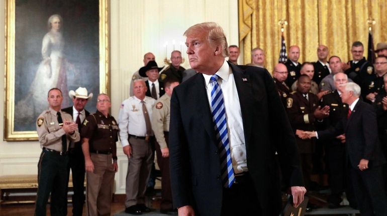 President Donald Trump listens to a question from a reporter during...