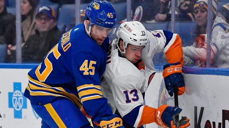 Buffalo Sabres defenseman Casey Fitzgerald and New York Islanders center...