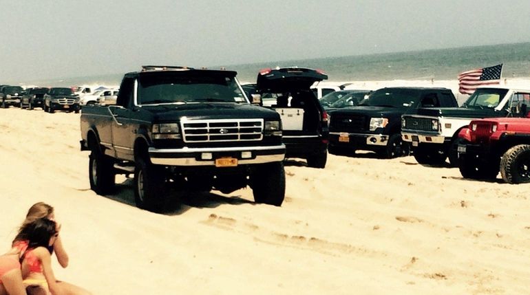 Trucks line the beach on the ocean east of Napeauge...