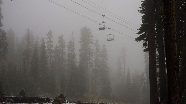 A coating of snow is seen below ski lifts at...