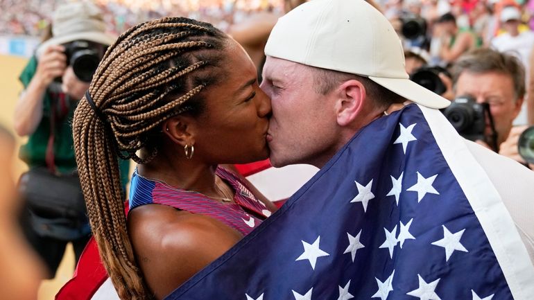 Tara Davis-Woodhall, of the United States, gets a kiss from...