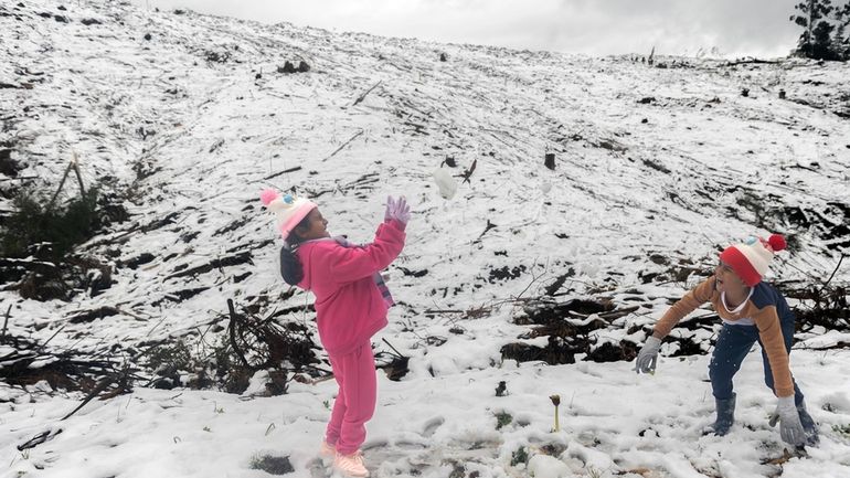 People play in unseasonal snow in Nottingham Road, near Durban,...