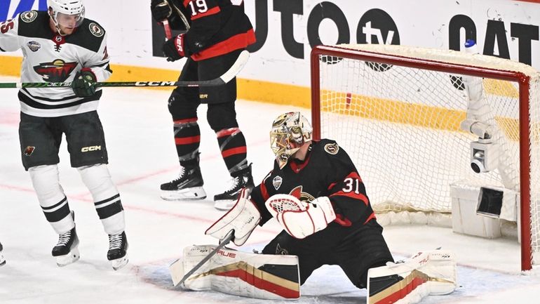 Minnesotas Jonas Brodin, left, and Ottawas goalkeeper Anton Forsbergi, right,...