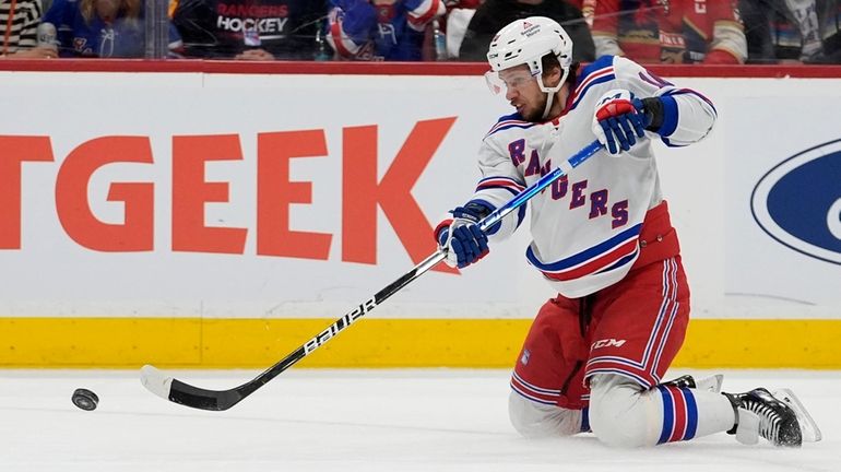 Rangers left wing Artemi Panarin falls to the ice as he...