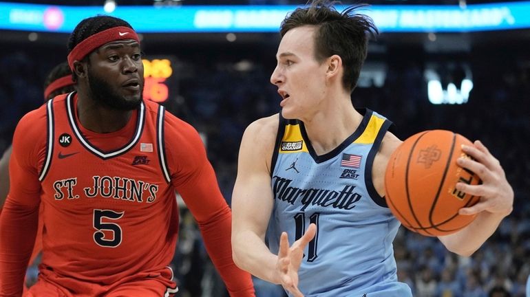 Marquette's Tyler Kolek drives by St. John's's Dylan Addae-Wusuduring the...