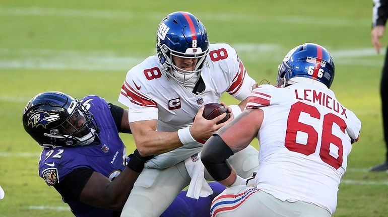 Baltimore Ravens defensive tackle Justin Madubuike, left, sacks New York...