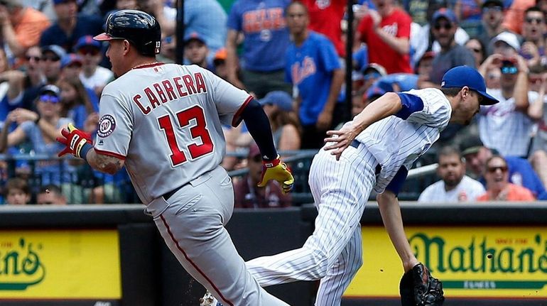 Mets pitcher Jacob deGrom can't come up with a ball thrown by first...