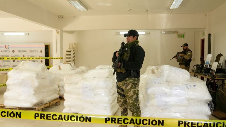 Agents from Paraguay’s anti-drug agency, Senad, guard sacks of cocaine...