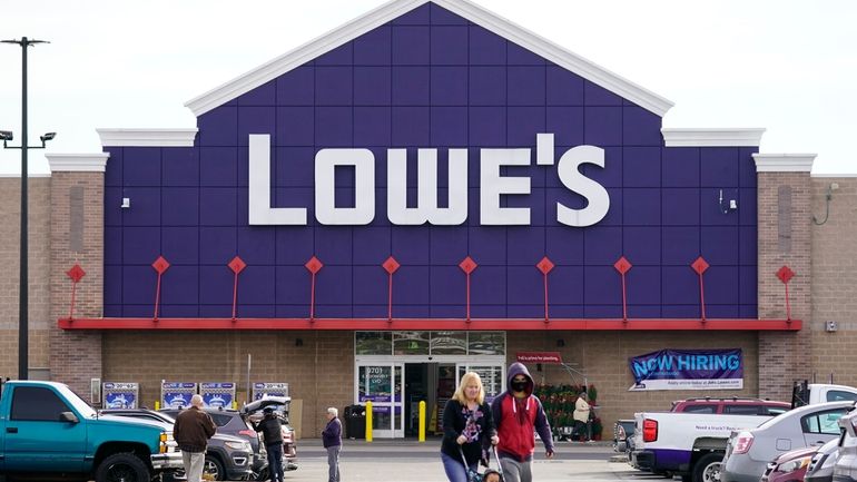 Shoppers walk in the lot of a Lowe's home improvement...