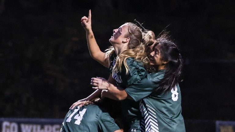 Breena Harrigan (center) is congratulated by her teammates after putting...