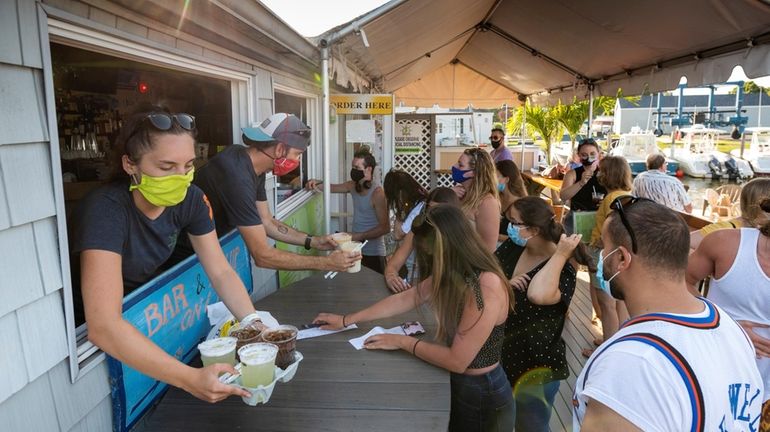 Restaurant owner Justin Tempelman, second left, and waitress Elizabeth Mason,...