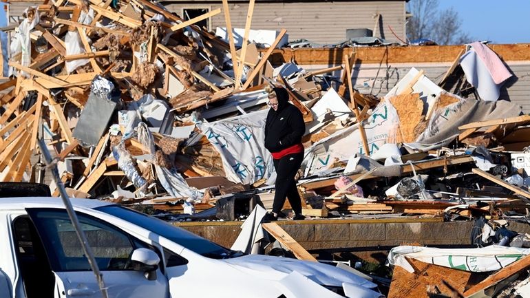 Amber Gardner looks at the debris from a friend's destroyed...