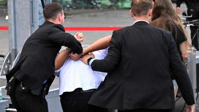 FILE -Bodyguards take away a man who allegedly carried out...