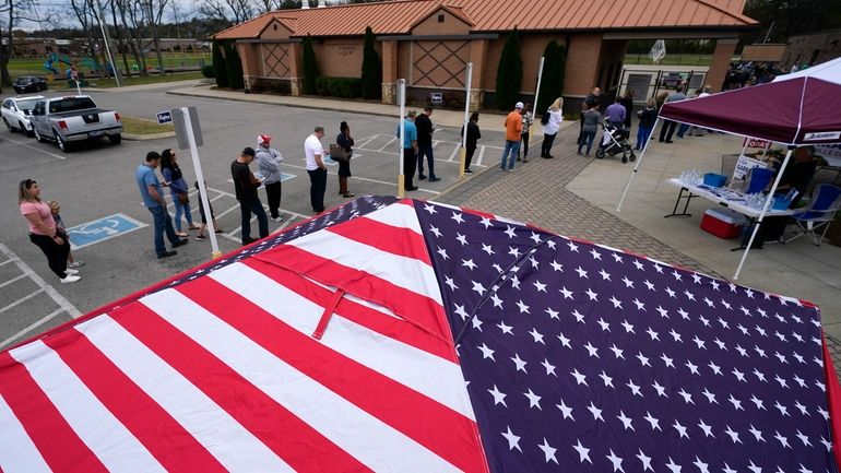 People line up to vote near tents set up by...