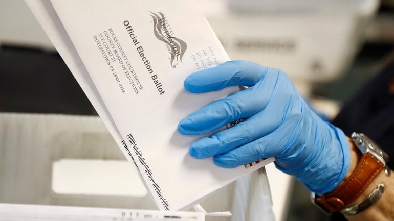 A worker processes mail-in ballots at the Bucks County Board...