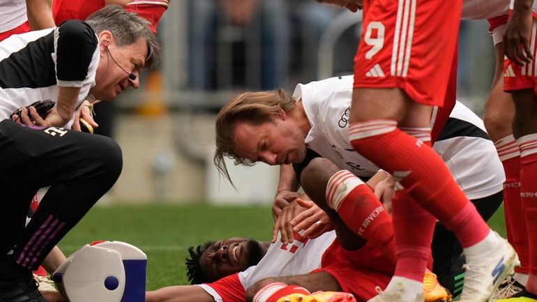 Injured Bayern's Kingsley Coman grimaces in pain during the German...