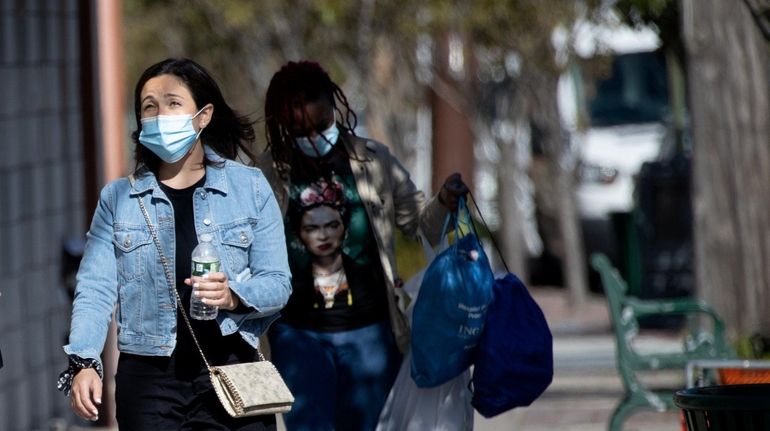 People walk down Central Avenue in Lawrence, where the school...