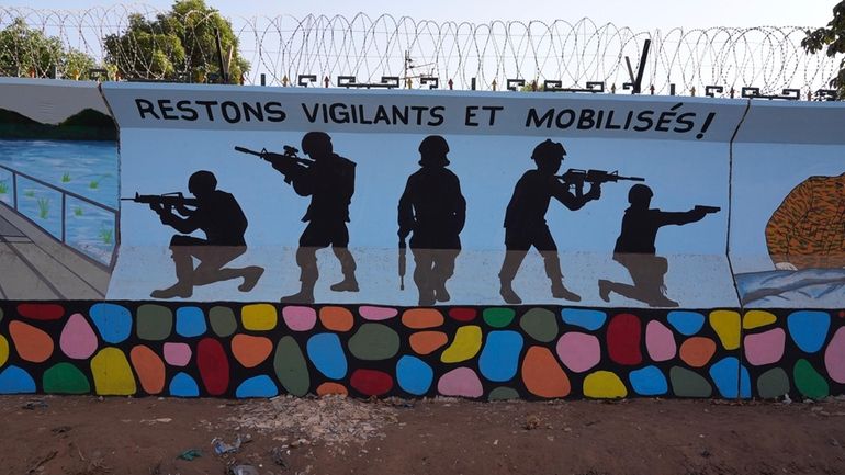 A mural reading " remain vigilant and mobilised" is seen...