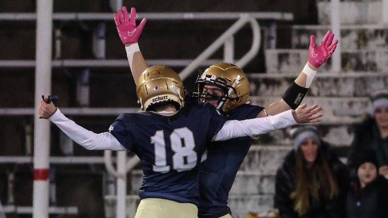 Bayport-Blue Point's Brendan Waters (18) celebrates Danny Aiello's first touchdown...