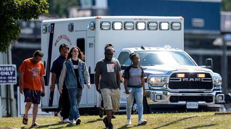 Students and parents walk off campus at Apalachee High School,...